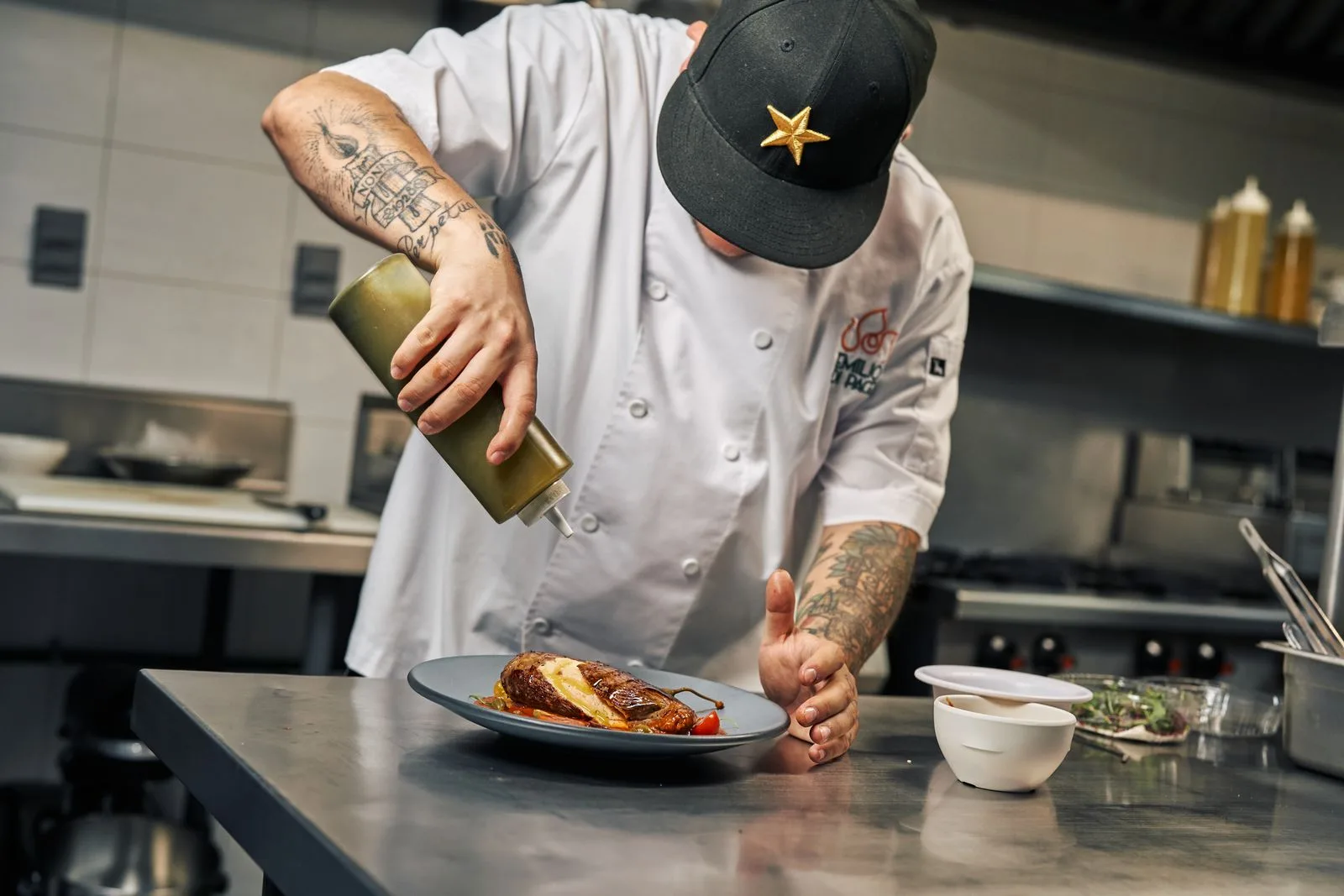 Le chef nappe un plat de sauce au moment du dressage, en cuisine