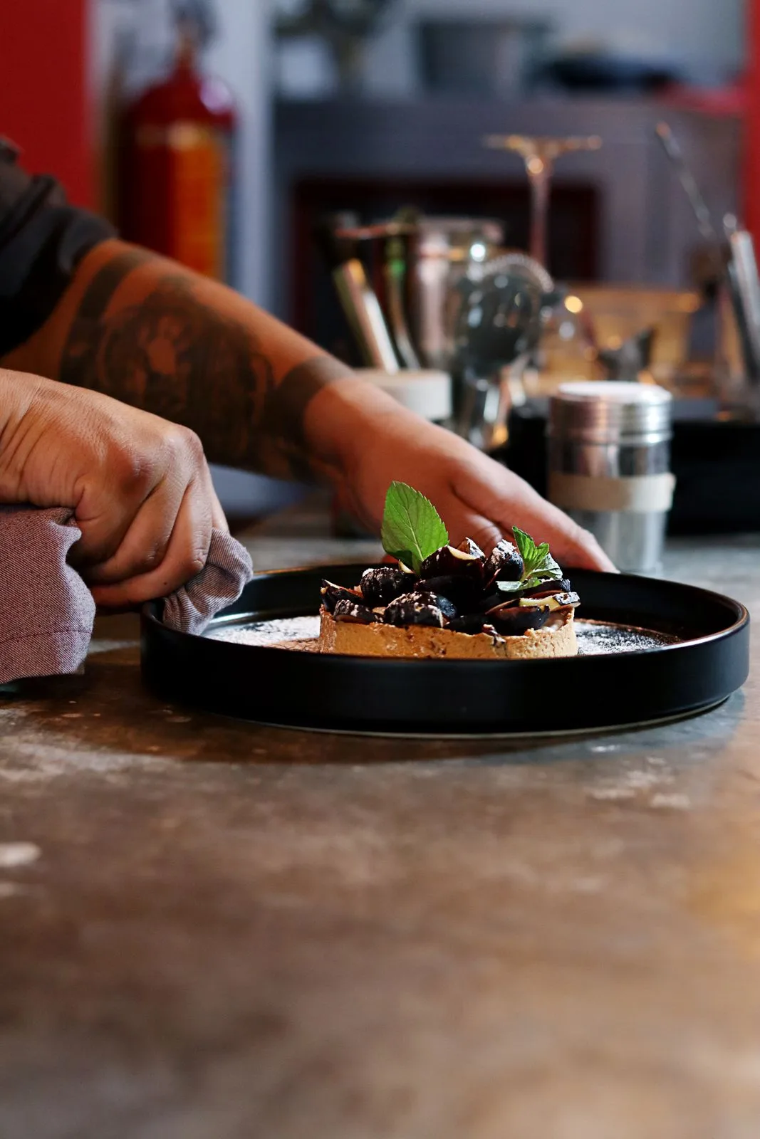 Le chef dresse un dessert avec précision dans une cuisine professionnelle