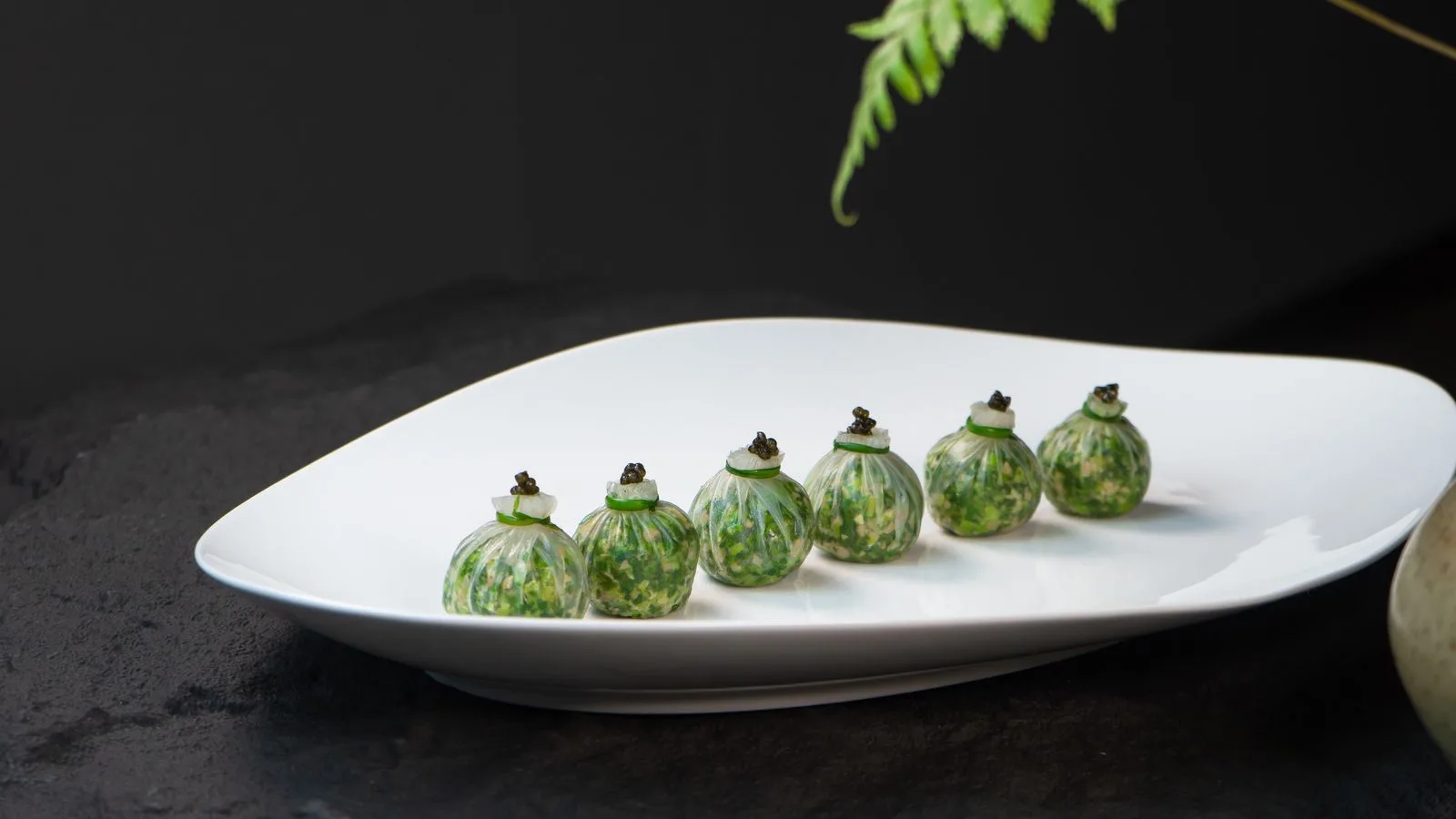 Assiette gastronomique dressée avec art sur une table sombre